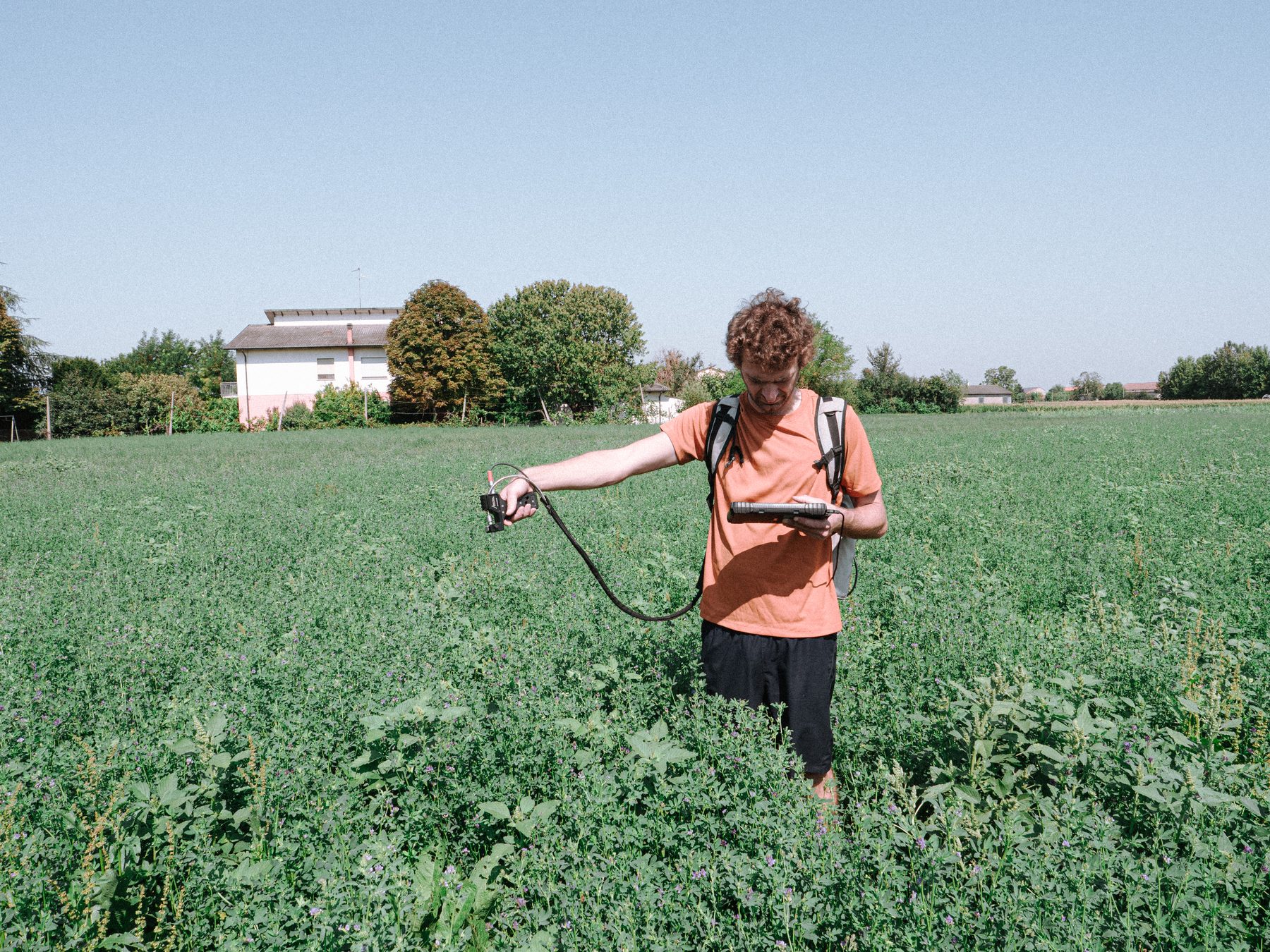 CNR-IBE field team member taking spectral measurements in a crop field during the July 2026 Italy campaign